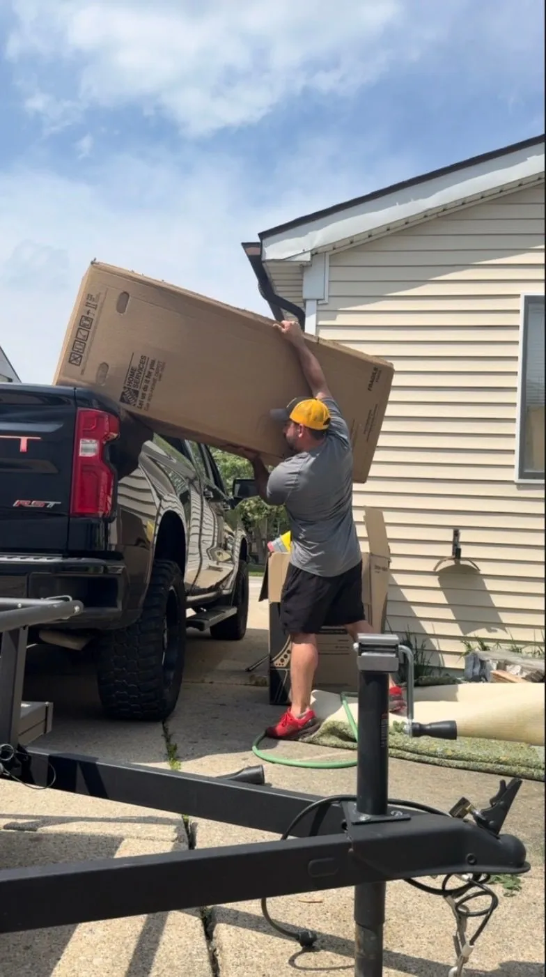 Bulky boxed items being carried out and loaded during a Demohaulic junk removal job in Roseville