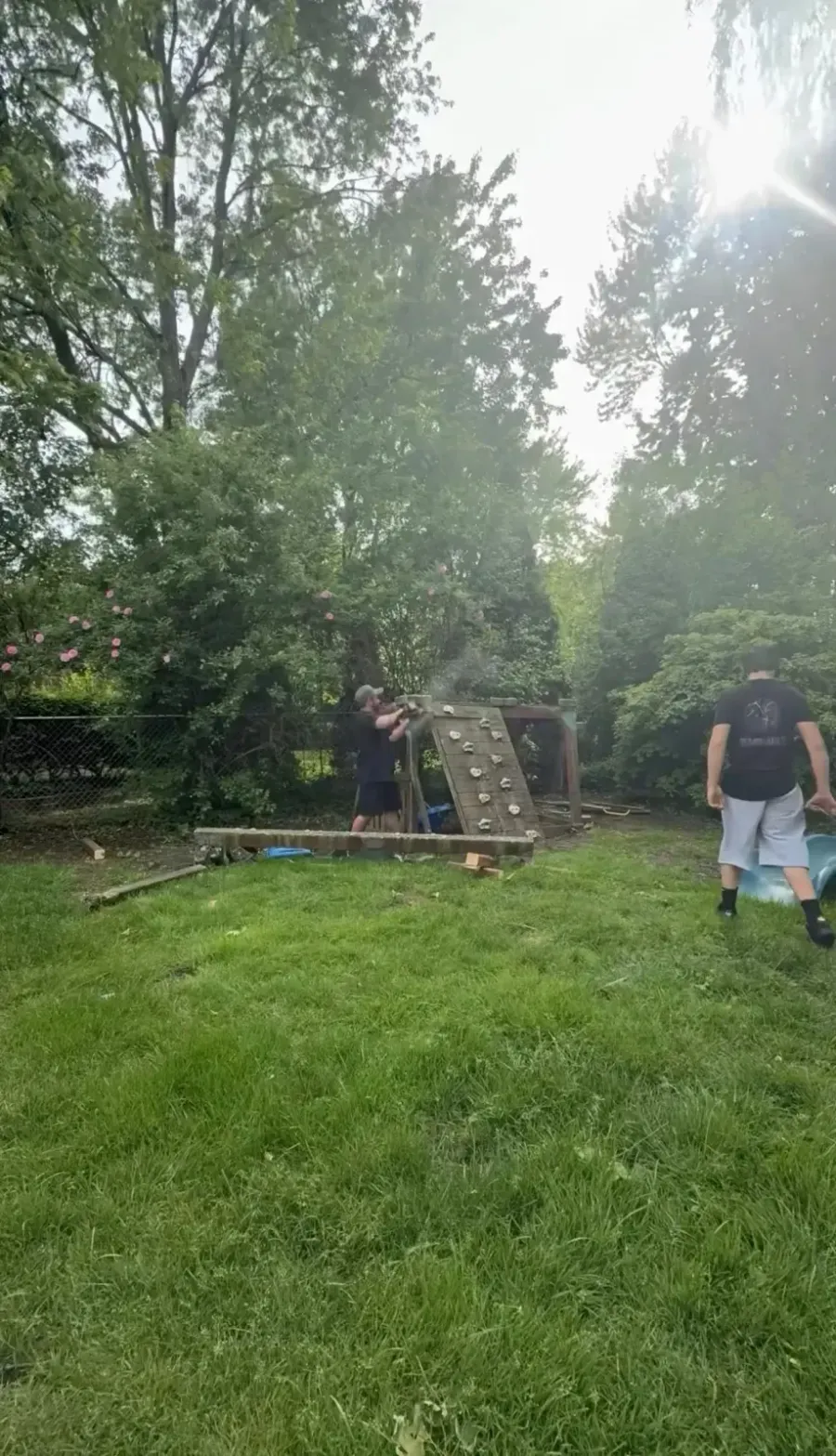 Crew dismantling a wooden playset during backyard demolition in Grosse Pointe Woods MI